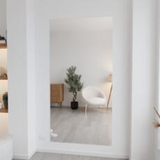 Verzilverd blanke spiegel zonder lijst aan de muur in lichte ruimte