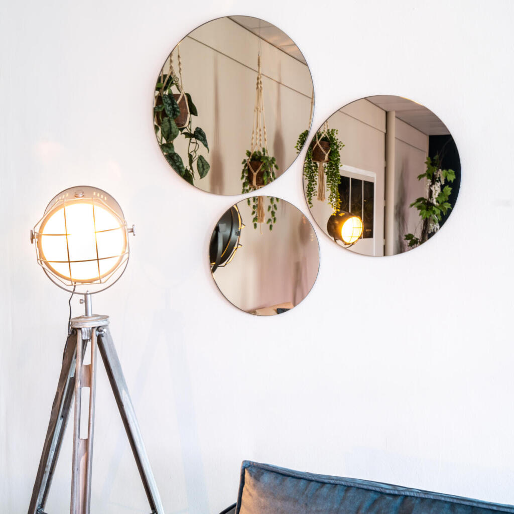 Drie ronde brons kleurige wandspiegels aan de muur bevestigd